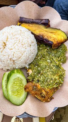 a plate with rice, cucumber and other food items on top of it