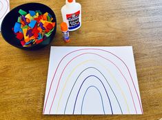 a table topped with lots of crafting supplies on top of a wooden table next to a bottle of glue