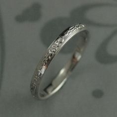 a close up view of a wedding ring on a table with the word love written in it