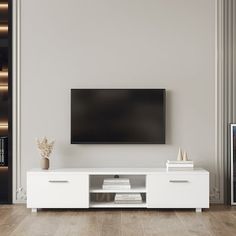 a flat screen tv sitting on top of a white entertainment center in a living room