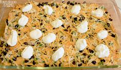 a casserole dish with cheese, olives and other toppings on it