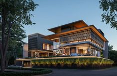 a large modern house sitting on top of a lush green hillside next to a forest