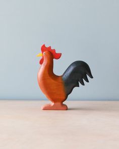 a small wooden rooster figurine on a table