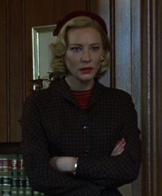 a woman with her arms crossed standing in a kitchen