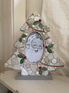 a christmas tree shaped photo frame sitting on top of a table