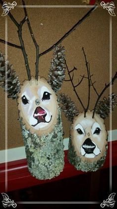 two deer made out of wood with pine cones on their heads