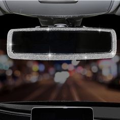 the front view mirror of a car with lights in the background and blurry cityscape