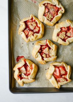 Mini Strawberry Galettes by Wood and Spoon blog. These are small open hand pies made with a simple butter dough and filled with fresh strawberries. On top an easy almond crumble adorns each dessert and a sprinkle of powdered sugar finishes them off. These little personal sized desserts are a special was to use summer produce and are sure to impress friends at parties. Find the recipe and how to on thewoodandspoon.com Strawberry Galettes, Strawberry Galette, Almond Crumble, Strawberry Icebox Cake, Wrote A Book, Favorite Pie, Small Desserts, Hand Pies, Mini Cookies