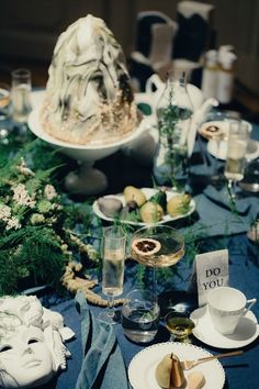 the table is set with plates, cups, and vases for an elegant dinner