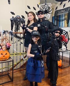 three children dressed up in halloween costumes posing for a photo with their mom and dad