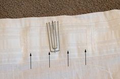 three pins are placed on top of a piece of fabric with four different sizes and shapes