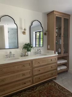 a large bathroom with two sinks and mirrors on the wall next to a doorway that leads to another room