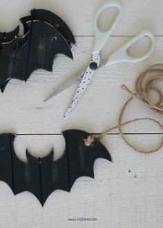 two bats cut out from wood with scissors and twine