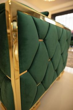 a green couch with gold trim on it