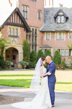 a bride and groom standing in front of a large house