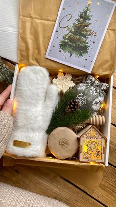 a person holding a box with christmas items in it