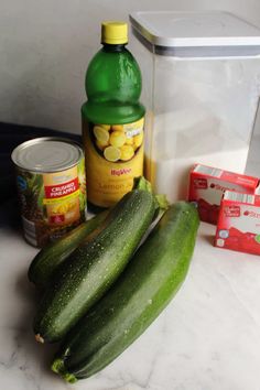 cucumbers, mustard, and other ingredients are sitting on a counter top next to a container