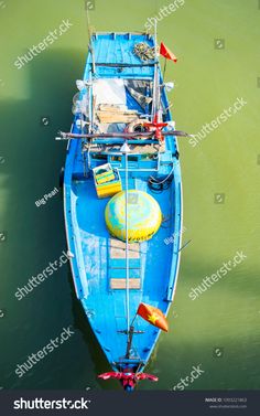 a small blue boat floating on top of water