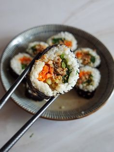 sushi on a plate with chopsticks ready to eat