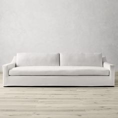 a white couch sitting on top of a hard wood floor