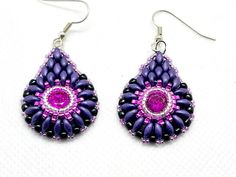 These gorgeous purple and pink teardrop earrings will give you endless compliments! They are reminiscent of peacock feathers. I created them using a bright pink chaton in the center, bezeled using silver and hot pink seed beads. Then I beaded matte deep purple superduos and finished with tiny, sparkly, silver beads. They are hung from hypoallergenic ear wires and come carded with stoppers. Purple Beaded Teardrop Earrings With Ear Wire, Purple Teardrop Beaded Earrings With Ear Wire, Purple Teardrop Beaded Earrings, Teardrop Earrings With Bead Caps For Gifts, Handmade Teardrop Purple Jewelry, Teardrop Earrings With Bead Caps As A Gift, Handmade Purple Teardrop Jewelry, Purple Beaded Teardrop Earrings, Pink Teardrop Beaded Earrings