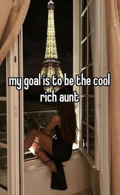 a woman sitting on a window sill in front of the eiffel tower