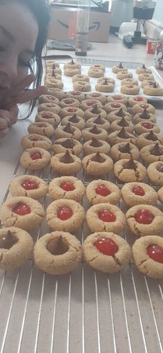 a woman looking at cookies with ketchup on them