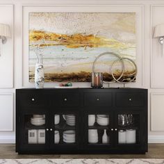 a black cabinet with plates and cups on it in front of a large art piece