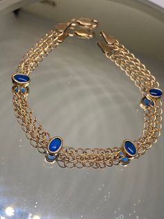 An Elegant Vintage 1970s Rolled Gold & Blue Sapphire Topaz Cabochons Double Strand Bracelet  7" Long x 5mm wide  Weight 2.93 grams  Presented in very good Vintage Condition with a secure Lobster Clasp  FREE UK TRACKED POSTAGE Vintage Blue Jewelry With Jubilee Bracelet, Vintage Blue Jubilee Bracelet Jewelry, Vintage Blue Oval Bracelets, Vintage Blue Oval Bracelet, Formal Blue Bracelets With Cabochon, Blue Gold Bracelet With 17 Jewels For Formal Occasions, Blue Oval Cabochon Formal Jewelry, Body Jewelry Piercing, Jewelry Lookbook