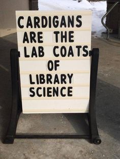 a sign that says cardigans are the lab coats of library science on it