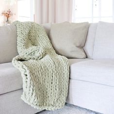 a white couch with a blanket on top of it