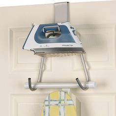 an ironing board mounted to the side of a door with a blue and white iron on it