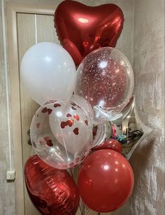 red and white balloons are hanging from a door handle in front of a bunch of heart - shaped balloons