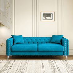 a blue couch sitting on top of a white rug