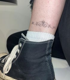 a woman's foot with a tattoo on her left ankle and the word love written in cursive writing