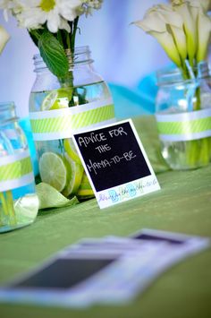 flowers in mason jars with a sign on the table