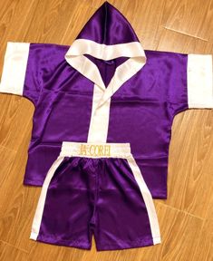 a purple and white robe laying on top of a wooden floor