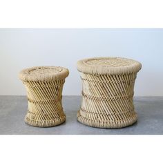 two wicker stools sitting next to each other on top of a gray floor