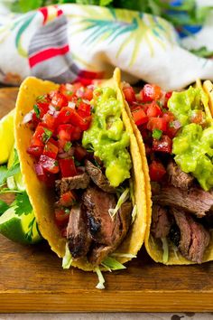 two steak tacos with guacamole and tomatoes