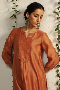 Spice orange kurta with placement leaf hand embroidery and scalloped sheer panelled sleeves. Paired with scalloped edge pant and embroidered dupatta.
Components: 3
Pattern: Embroidered
Type Of Work: Nakshi, Zari
Neckline: Notched
Sleeve Type: Scallop
Fabric: Kurta and Dupatta: Chanderi, Pant: Cotton Satin, Lining: Cotton
Color: Orange
Other Details: 
Length:
Kurta: 43 inches
Pant: 36 inches
Dupatta (LXW): 90 X 20 inches
Occasion: Puja - Aza Fashions Satin Dupatta, Chudidhar Neck Designs, Kurta And Dupatta, Embroidered Leaf, Chanderi Dupatta, Kurta Patterns, Simple Kurta Designs, Upcycling Ideas, Kurta Designs Women