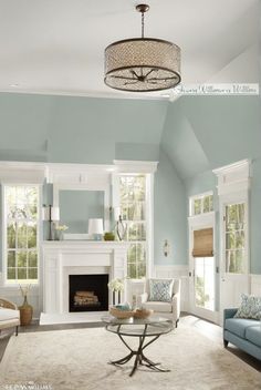 a living room filled with furniture and a fire place under a chandelier above a fireplace