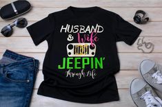 Get ready for an adventurous ride with our Husband & Wife Jeepin' Through Life t-shirt! Made from premium quality fabric, this black tee features the fun slogan "Husband and Wife Jeepin' Through Life". Perfect for couples who love off-roading, this shirt will keep you stylishly united while conquering any terrain. Buckle up and embrace the thrill of the journey together! Off Roading, Les Couples, Husband And Wife, Husband Wife, The Journey, Black Tee, Quality Fabric, Jeep, Gender Neutral