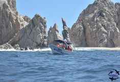 a boat in the water near some rocks