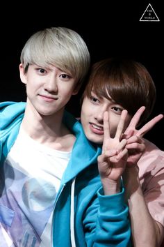 two young men posing for the camera with their hands in the shape of peace signs