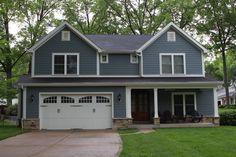 a blue house with white trim and two car garages