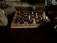 two people sitting at a table playing chess