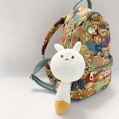 a small backpack with a stuffed animal in the front, and a teddy bear on the back