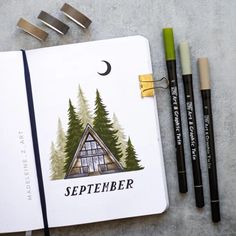 an open notebook with the words september written on it next to some markers and pencils