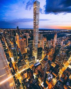 an aerial view of a city at night with skyscrapers lit up in the background