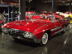 several classic cars are on display in a museum